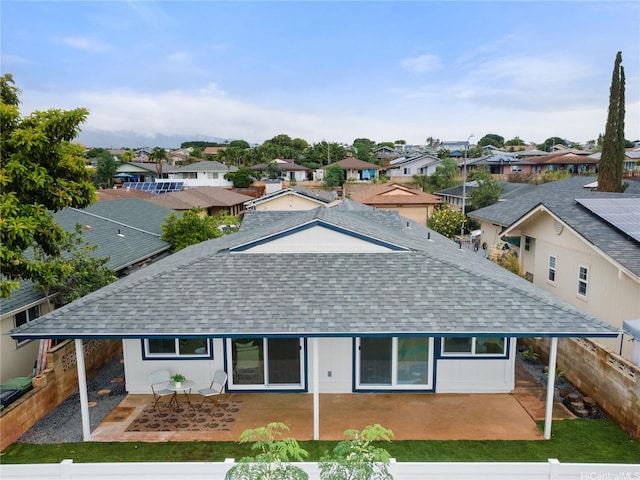 exterior space featuring roof with shingles, a fenced backyard, a patio area, and a residential view