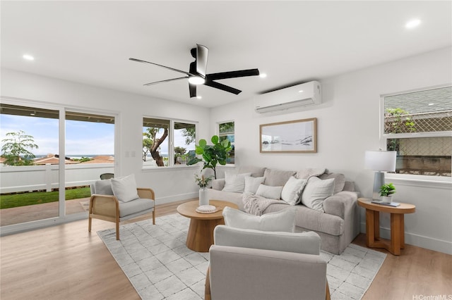 living area featuring light wood-type flooring, recessed lighting, a wall mounted air conditioner, and a wealth of natural light
