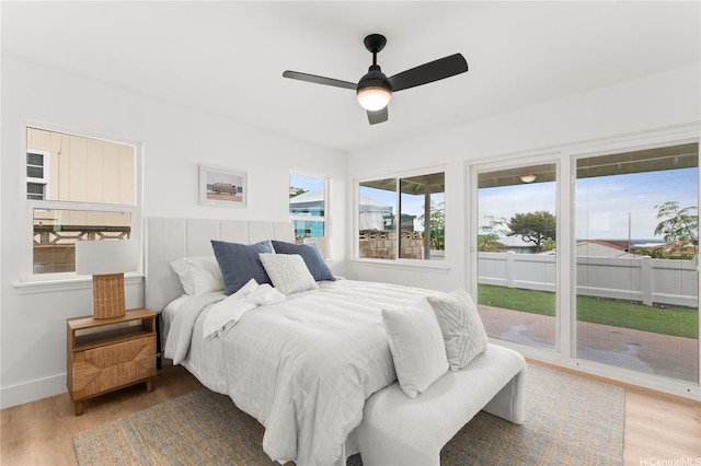 bedroom featuring baseboards, a ceiling fan, wood finished floors, and access to exterior