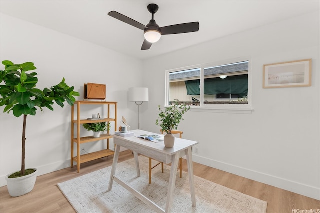 home office with baseboards, light wood-style flooring, and ceiling fan