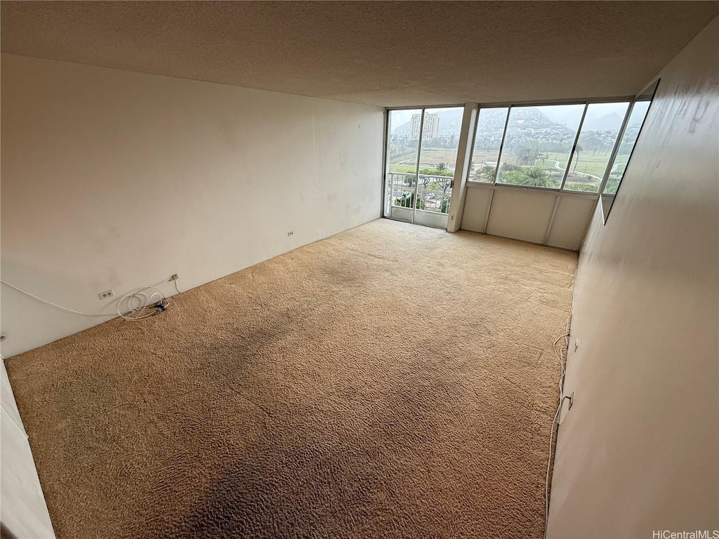 2611 Ala Wai St Unit 806, Honolulu, HI 96815 - unfurnished room with a textured ceiling, light colored carpet, and a wall of windows