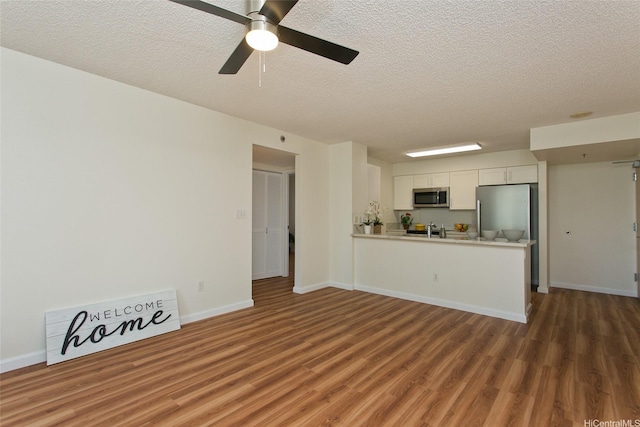 1133 Waimanu St Unit 201, Honolulu, HI 96814 - unfurnished living room featuring a textured ceiling, baseboards, a ceiling fan, and wood finished floors