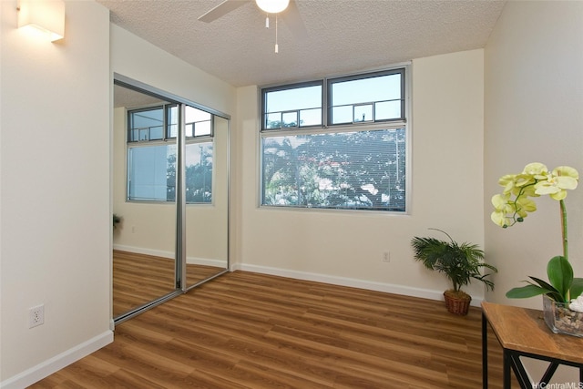 1133 Waimanu St Unit 201, Honolulu, HI 96814 - unfurnished bedroom featuring baseboards, a textured ceiling, ceiling fan, and wood finished floors
