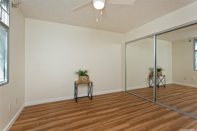 1133 Waimanu St Unit 201, Honolulu, HI 96814 - unfurnished bedroom featuring baseboards, a textured ceiling, wood finished floors, and a closet