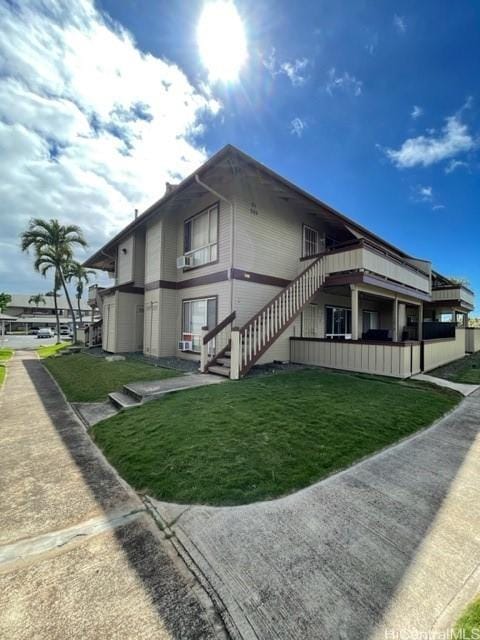 view of property exterior featuring a yard and stairs