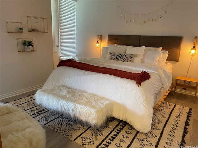 bedroom with baseboards and wood finished floors