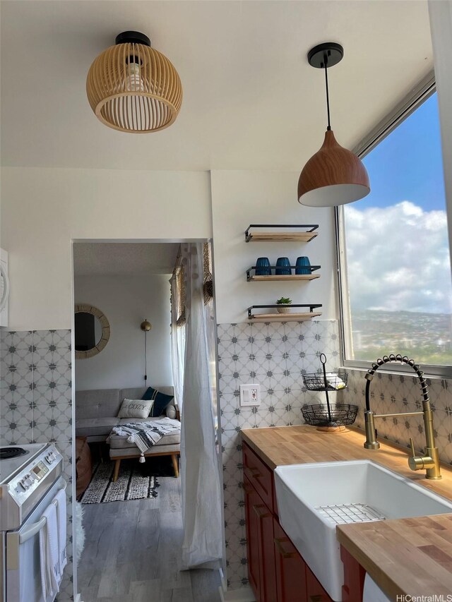 444 Nahua St Unit 1104, Honolulu, HI 96815 - interior space featuring butcher block counters, white electric range, a sink, plenty of natural light, and tile walls