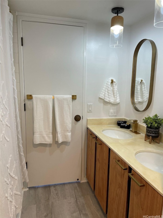full bathroom with wood finished floors, double vanity, and a shower with curtain
