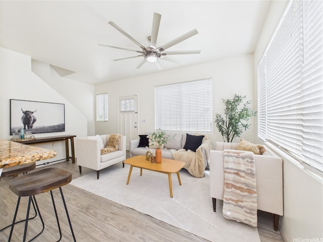 living area with light wood-style flooring and ceiling fan