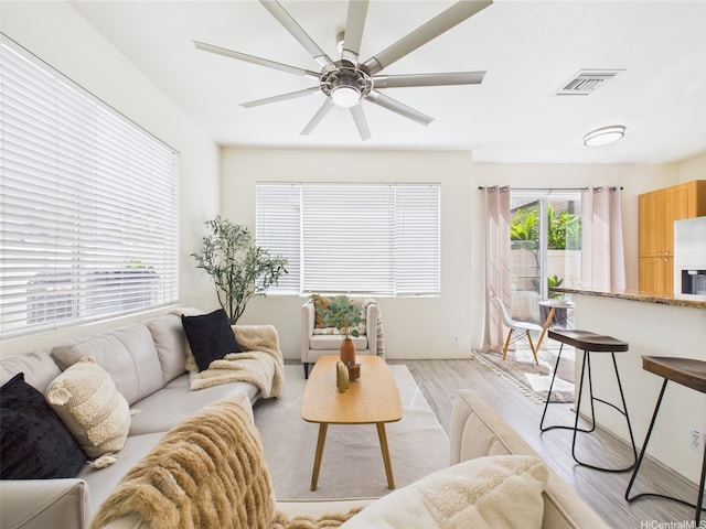 living room with light wood finished floors and a ceiling fan