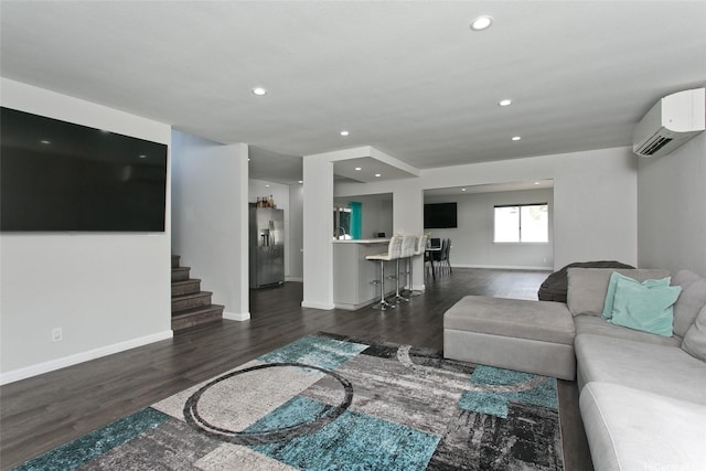 living area featuring stairs, recessed lighting, baseboards, dark wood-type flooring, and a wall mounted AC