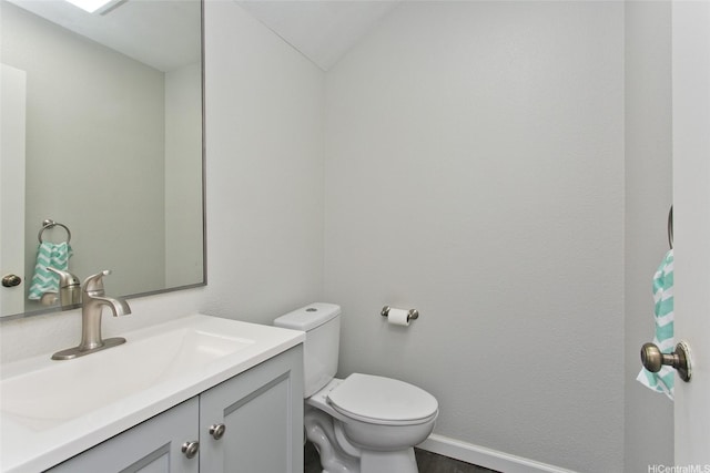 bathroom featuring vanity, baseboards, and toilet