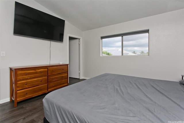 bedroom with baseboards, dark wood-style flooring, and lofted ceiling