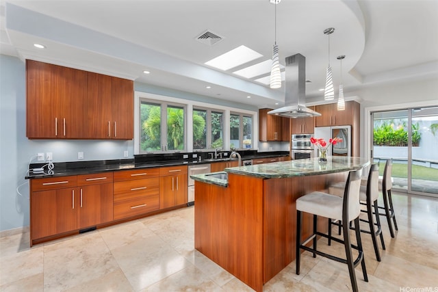 45-020 Namoku St, Kaneohe, HI 96744 - kitchen with island range hood, brown cabinets, a kitchen breakfast bar, appliances with stainless steel finishes, and a raised ceiling