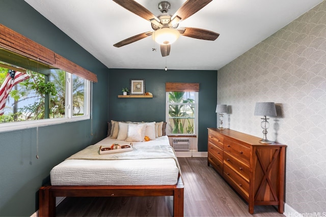 92-1288 Kikaha St Unit 78, Kapolei, HI 96707 - bedroom featuring an accent wall, multiple windows, wallpapered walls, and wood finished floors