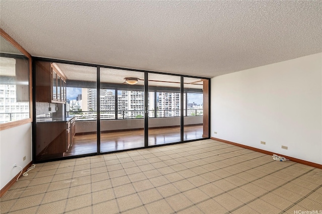 581 Kamoku St Unit 1008, Honolulu, HI 96826 - spare room featuring plenty of natural light, a textured ceiling, and baseboards