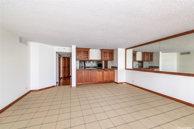 581 Kamoku St Unit 1008, Honolulu, HI 96826 - unfurnished living room with visible vents, a textured ceiling, and baseboards
