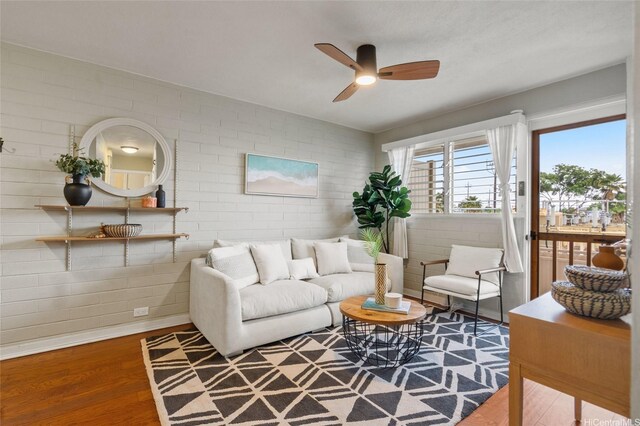 75 Kihapai St Unit 10, Kailua, HI 96734 - living room featuring a ceiling fan, brick wall, and wood finished floors