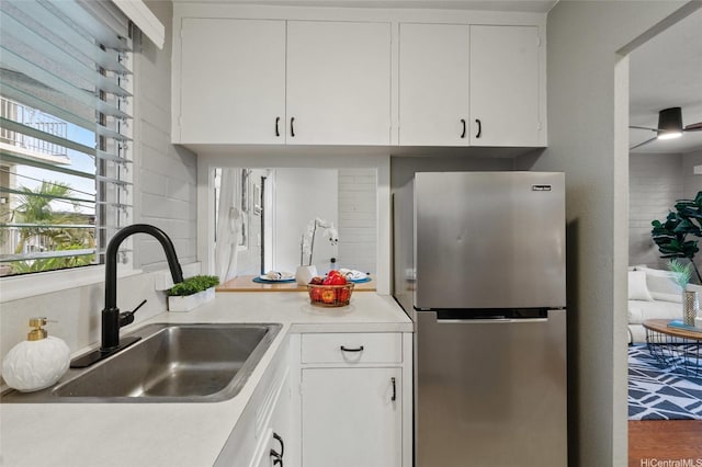 75 Kihapai St Unit 10, Kailua, HI 96734 - kitchen featuring freestanding refrigerator, a sink, white cabinets, and light countertops