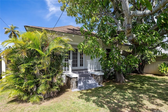 view of home's exterior featuring a yard, fence, and french doors