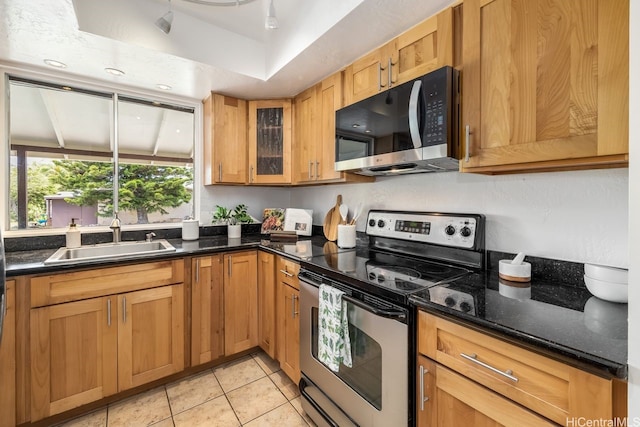 6215 Kawaihae Pl Unit B102, Honolulu, HI 96825 - kitchen featuring appliances with stainless steel finishes, a sink, light tile patterned floors, glass insert cabinets, and dark stone counters