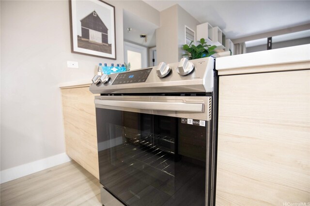 229 Paoakalani Ave Unit 1513, Honolulu, HI 96815 - details featuring baseboards, stainless steel electric range, and wood finished floors