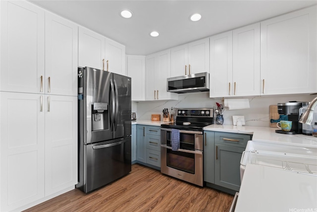 401 Opihikao Pl Unit 272, Honolulu, HI 96825 - kitchen with appliances with stainless steel finishes, light countertops, white cabinets, wood finished floors, and gray cabinets