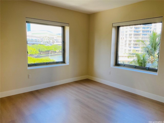 empty room with baseboards and wood finished floors