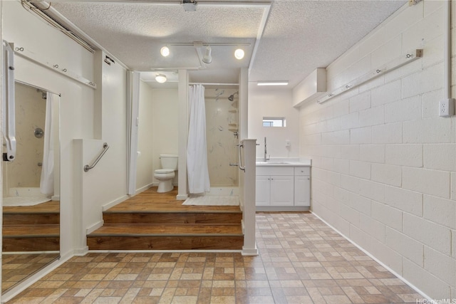 98-512 Kaonohi St Unit 49-3, Aiea, HI 96701 - bathroom featuring vanity, toilet, a textured ceiling, concrete block wall, and a shower stall