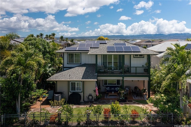 91-1243 Kuanoo St, Ewa Beach, HI 96706 - back of property with a balcony, a fenced backyard, solar panels, a shingled roof, and a patio area