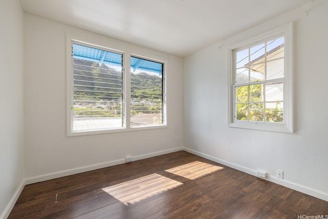 empty room featuring dark wood-type flooring and baseboards
