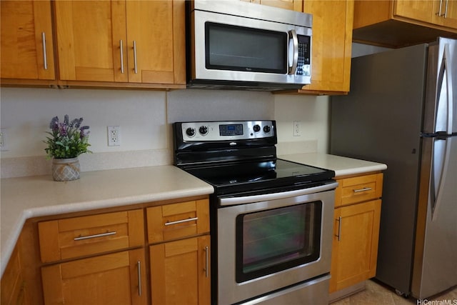 kitchen featuring light countertops, brown cabinets, and appliances with stainless steel finishes