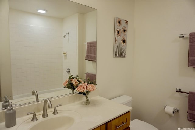 bathroom with vanity, toilet, and a shower