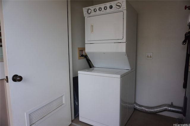 laundry room with stacked washer / drying machine and laundry area
