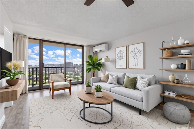 1201 Wilder Ave Unit 2701, Honolulu, HI 96822 - living area featuring a wall mounted AC, a textured ceiling, wood finished floors, ceiling fan, and a wall of windows