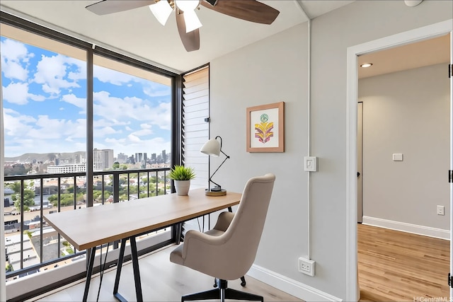 1201 Wilder Ave Unit 2701, Honolulu, HI 96822 - office with baseboards, a ceiling fan, a view of skyline, wood finished floors, and a wall of windows