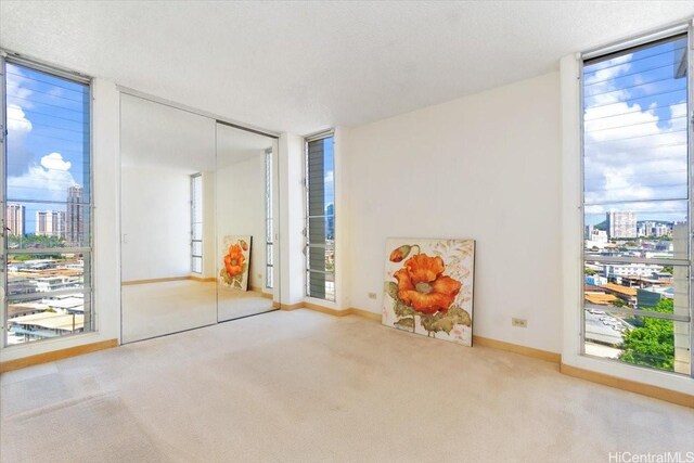 796 Isenberg St Unit 11A, Honolulu, HI 96826 - interior space with a view of city, carpet flooring, multiple windows, and baseboards