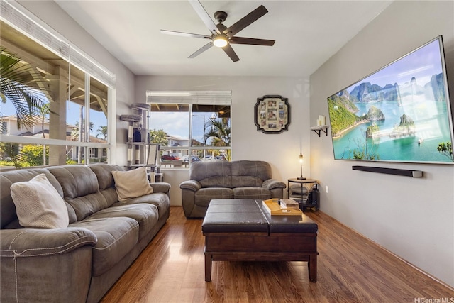 living area with a ceiling fan and wood finished floors