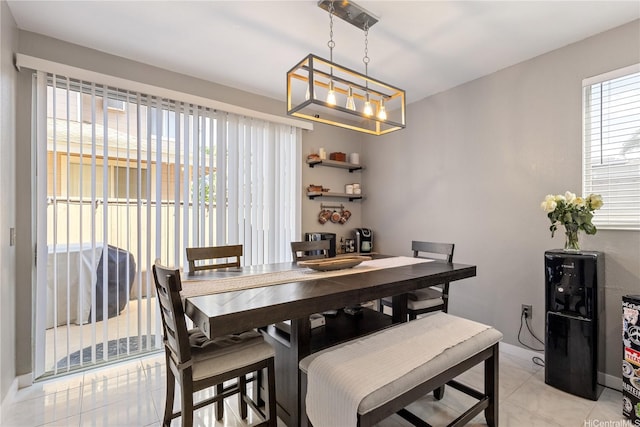 dining room with light tile patterned flooring, baseboards, and an inviting chandelier
