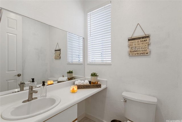 bathroom with a sink, plenty of natural light, and toilet