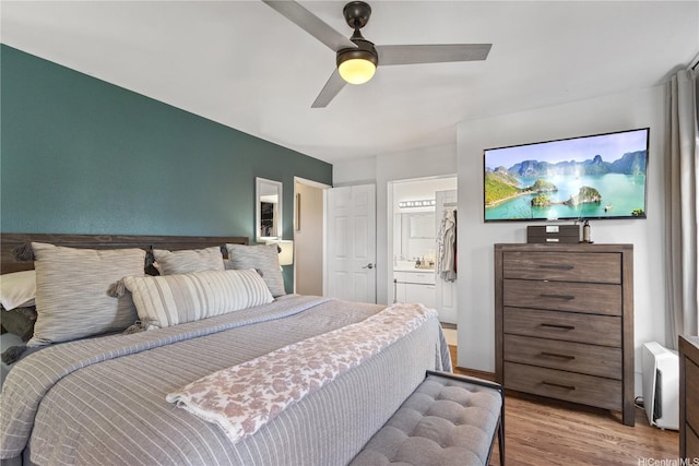 bedroom featuring a ceiling fan, wood finished floors, and ensuite bath