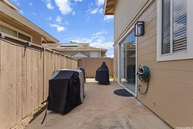 view of patio with fence and a grill
