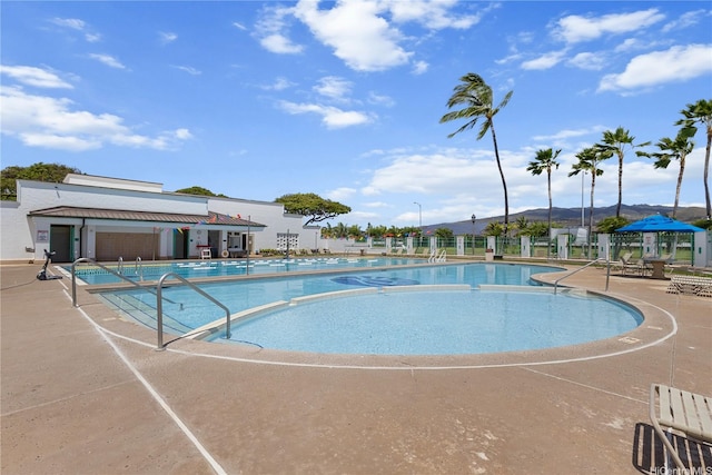 pool with fence and a patio area