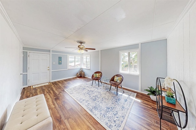 living area featuring crown molding, a ceiling fan, and wood finished floors