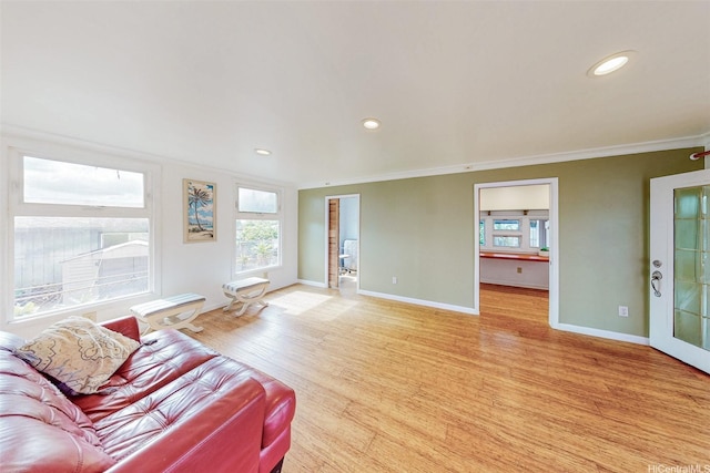 living area featuring recessed lighting, ornamental molding, light wood finished floors, and baseboards
