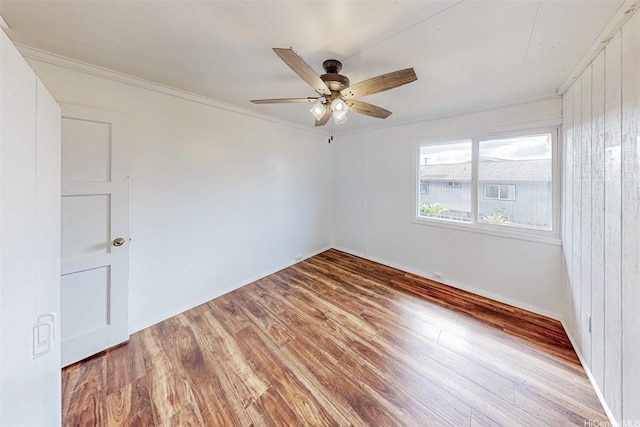 empty room featuring crown molding, a ceiling fan, and wood finished floors