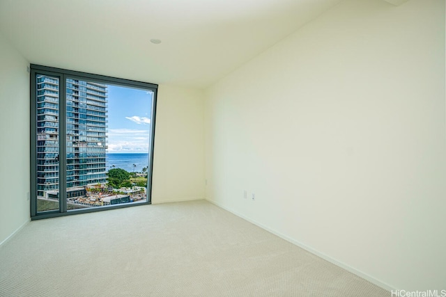 1000 Auahi St Unit 1404, Honolulu, HI 96814 - carpeted empty room with a wall of windows, a water view, and baseboards