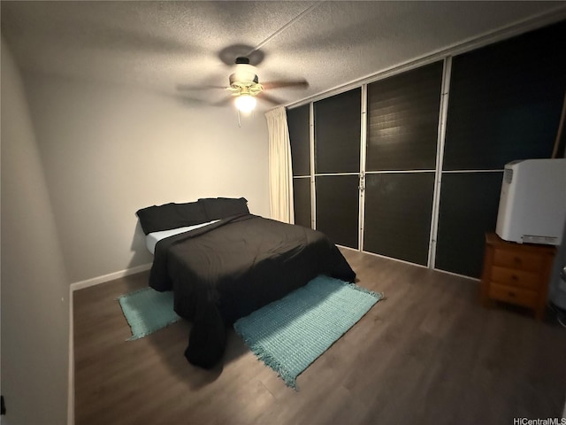95-020 Waihonu St Unit C402, Mililani, HI 96789 - bedroom with a textured ceiling, baseboards, a ceiling fan, and wood finished floors