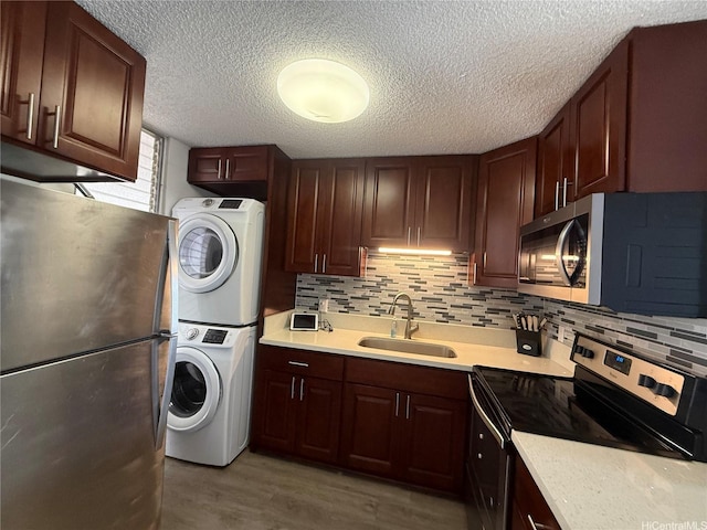 95-020 Waihonu St Unit C402, Mililani, HI 96789 - kitchen featuring light countertops, stainless steel appliances, stacked washer / drying machine, and a sink
