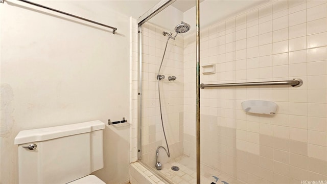 bathroom with a stall shower and toilet